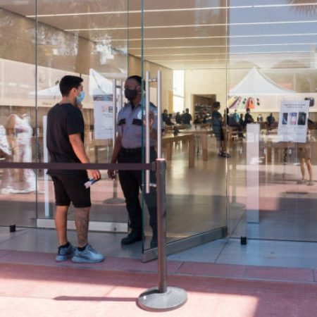 Miami Beach, Florida USA - June 16, 2020 - An employee and customer wear face masks on Lincoln Road Mall during the coronavirus pandemic.